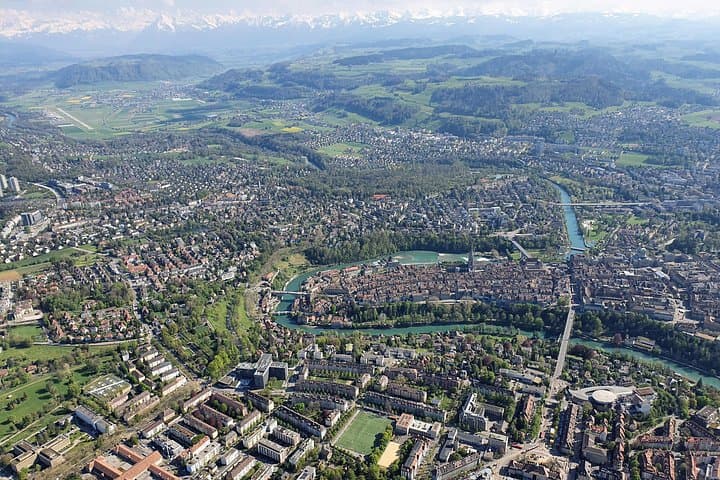 The view on an afternoon City-Tour flight with the old town and the mountains in the back.
