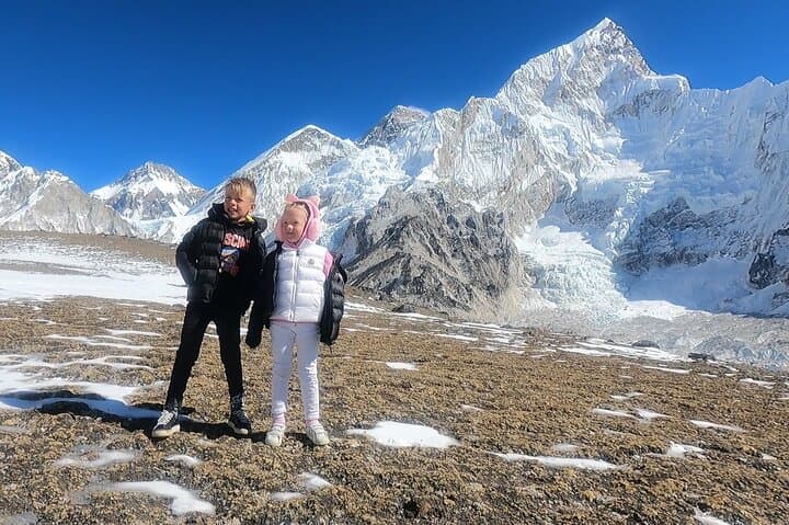 Picture in front of tall and sharp peak of Nuptse, Everest is black colored and just to the left side of Nuptse